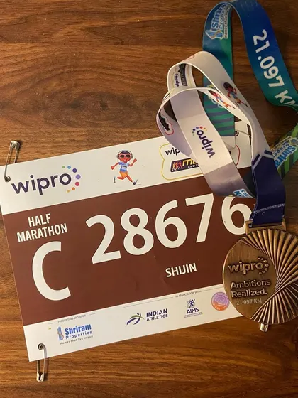 The reward for all the hard work. A finisher's medal and bib from the Wipro Half Marathon, marking a huge personal achievement for this runner.