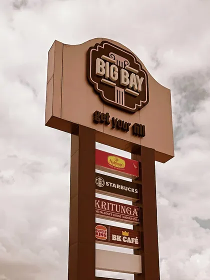 A close-up of our main pylon sign, listing some of our top brands against a dramatic sky.