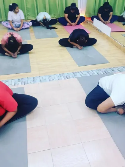 Students in Baddha Konasana (Bound Angle Pose) with a forward bend. This pose is excellent for opening the hips and releasing tension in the inner thighs.