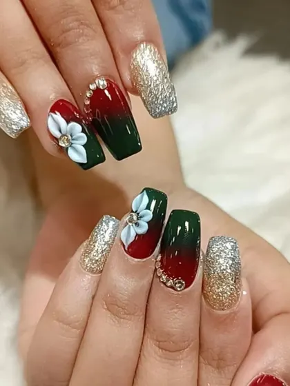 A luxurious holiday design with a red and green ombre, 3D white flowers, and sparkling rhinestones and glitter.