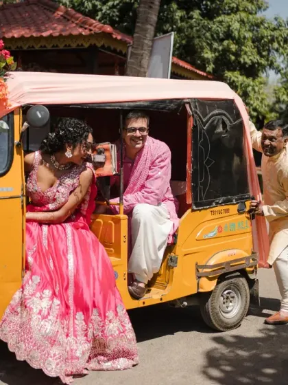 A fun and quirky shot of the couple in a decorated auto-rickshaw, with the bride's father joining in. This photo is full of personality and captures a unique family moment.