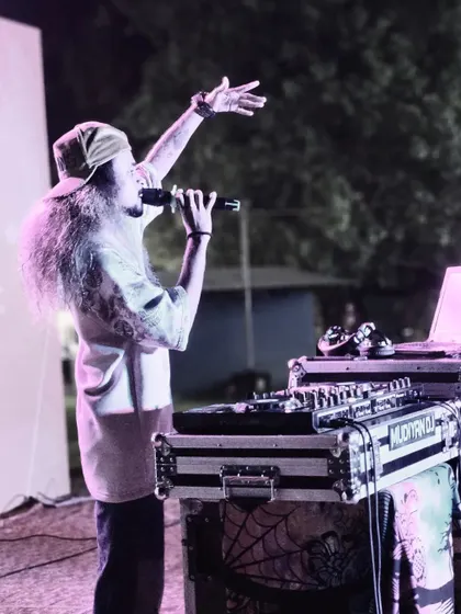 A side view of me on the mic during an outdoor festival performance.