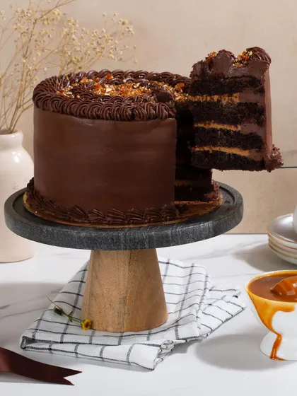 A slice being lifted from my Dark Chocolate & Salted Caramel Cake, showing the rich, dark layers of chocolate cake and silky caramel filling.