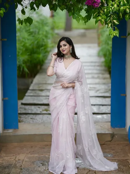 A blush pink hand-embroidered saree, exuding elegance and delicacy.