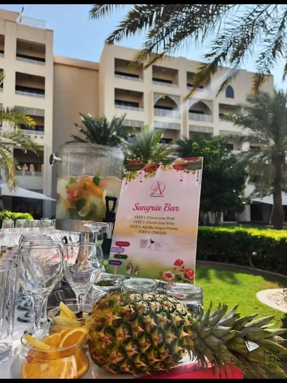 A fresh and fruity Sangria Bar set up for an outdoor event. With a large dispenser of chilled sangria and plenty of fresh fruit, it's a perfect and refreshing option for a sunny day.