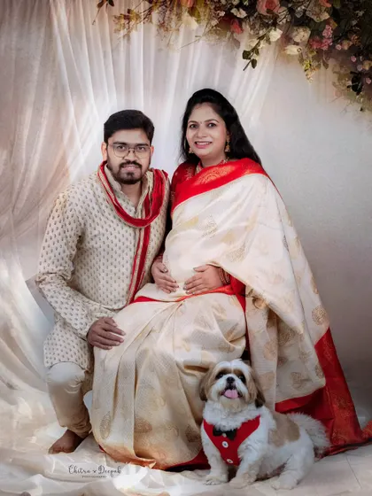 A complete family portrait in traditional attire. The couple and their pet look picture-perfect against a soft, elegant backdrop.