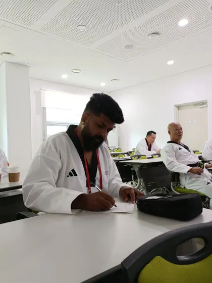 Theory is as important as practice. Taking notes during a seminar at the World Taekwondo training program in South Korea.