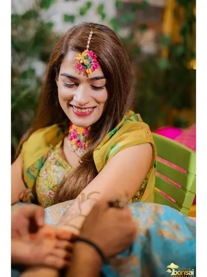 A close-up of the bride smiling as her Mehndi is applied.