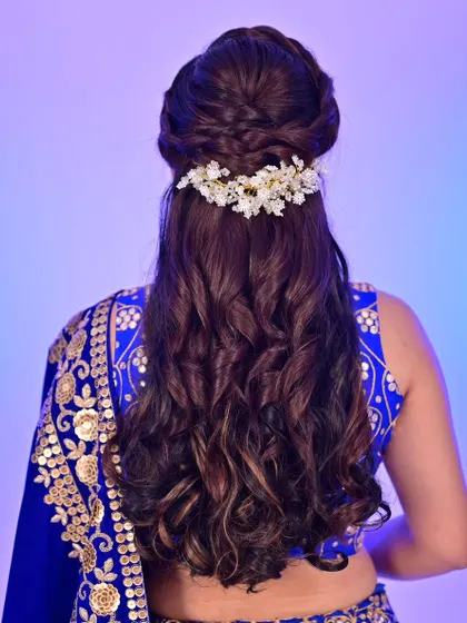 The hairstyle is just as important as the makeup. For this look, I created an intricate braided half-updo with delicate floral accessories, adding a touch of romance that complements the elegant bridal lehenga.