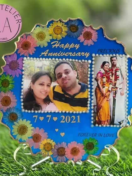 A bright and happy anniversary frame. This blue resin piece features two photos, the anniversary date, and a border of cheerful, multicolored flowers.