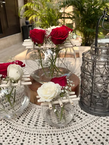 Here you can see a collection of my Christmas floral arrangements. I used glass vases of different sizes with red and white roses, paired with a rustic lantern to create a cozy and coordinated holiday look.