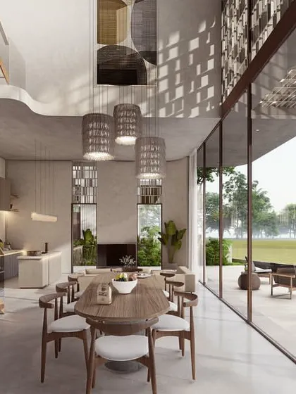 The double-height living and dining area of a Pavilion home looks directly out over the paddy fields. The space is flanked by a large patio and pool, creating a fluid transition from the built environment to the natural one.
