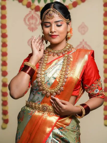 A three-quarter portrait showing the full splendor of the bridal attire. The pose is traditional and graceful, capturing the essence of a South Indian bride.