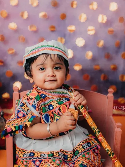 This little one looks so adorable in her traditional Gujarati outfit, complete with a cap and dandiya stick.
