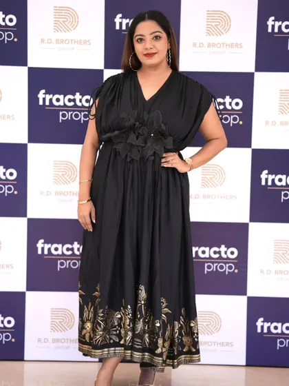 Posing in front of the media wall at the Fracto Prop launch. Such backdrops are a key feature of corporate events, and as a host, I ensure they get visibility.