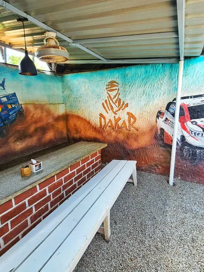 A wide shot of our Dakar Rally themed mural at Burnout Café. The artwork spans across the wall, featuring a rally truck, a Toyota Hilux, and the iconic Dakar logo, setting an adventurous tone for the space.