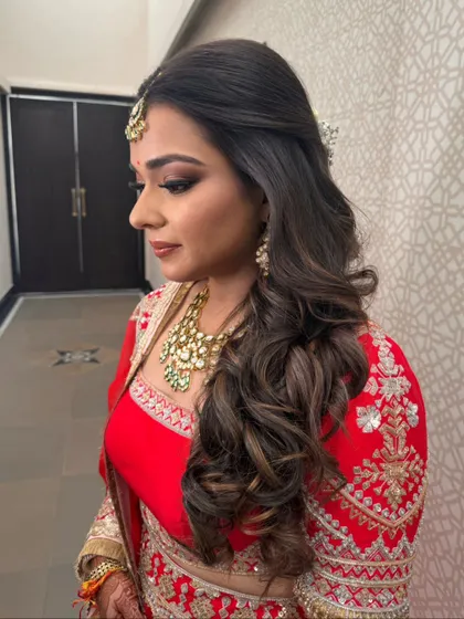 A side profile of the bride, highlighting the soft waves and the placement of the baby's breath accessory.