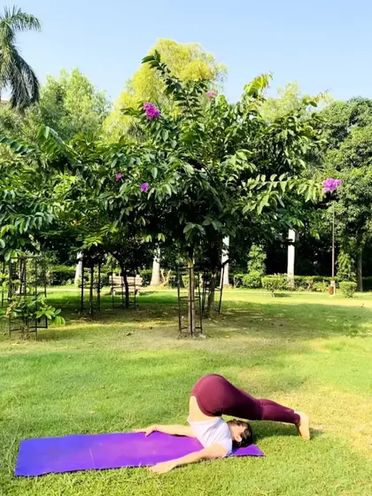 My student performing Halasana (Plow Pose) outdoors. This pose is a blessing for the spine, helping to relieve back pain and stimulate the thyroid gland.