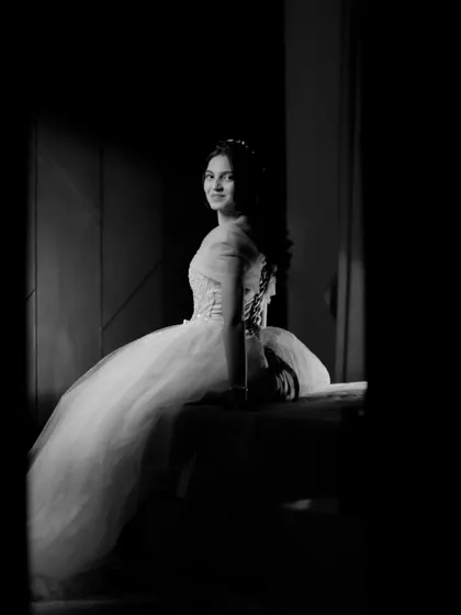 A stunning black and white portrait of the bride-to-be sitting by a window, using shadows and light to create a timeless, artistic image.