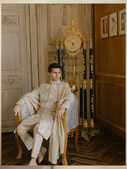 A solo portrait of the groom, looking regal and thoughtful. The antique clock in the background adds to the timeless, classic feel of the shot.