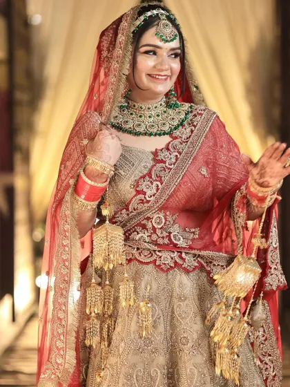 A playful and happy bride, showcasing her full attire and the stunning kalire that are part of her traditional look.