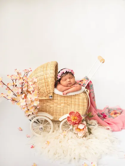 There is nothing more precious than a brand new baby. For my newborn photography sessions, I love using classic props like this wicker pram and soft florals to create a timeless, peaceful portrait of your little one.