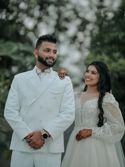 A classic couple portrait. The bride's adoring glance at her groom captures the love and admiration between them, set against a beautiful green backdrop.