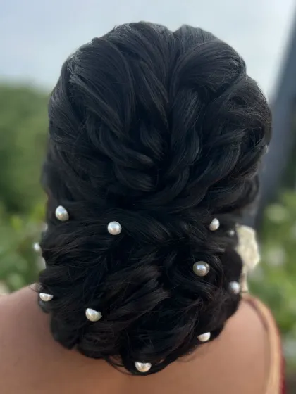 A closer view of the pearl-studded textured bun, showing the intricate weaving of the hair.