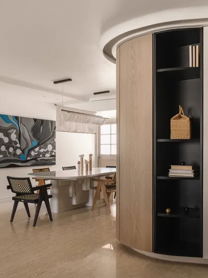A wide shot of the dining area, showing the curved wall that leads into the space and the dramatic artwork that anchors it.