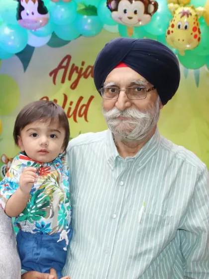 A grandfather holds his young grandson at a jungle-themed party. We love capturing precious moments between different generations of a family.