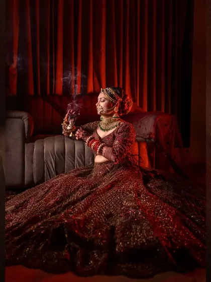 A dramatic, low-light portrait of the bride seated on a couch, looking regal.