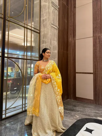 Another angle of this stunning yellow lehenga, highlighting the way the light catches the embroidery on the sheer dupatta.