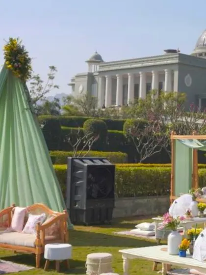 A wide view of the outdoor lounge, showing the mix of tented seating, traditional sofas, and the grand palace hotel in the background.