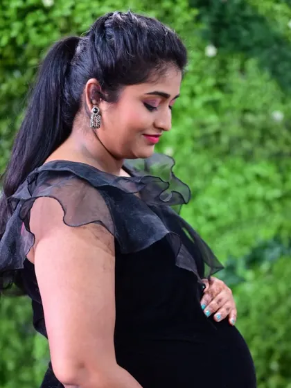 A simple and elegant black velvet bodycon dress, perfect for a chic and modern maternity photoshoot.