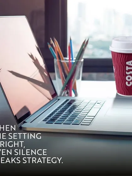 A laptop open and ready for work next to a cup of Costa coffee. This image reinforces the idea that when the setting is right, even silence speaks strategy, making my cafes ideal for focused work.