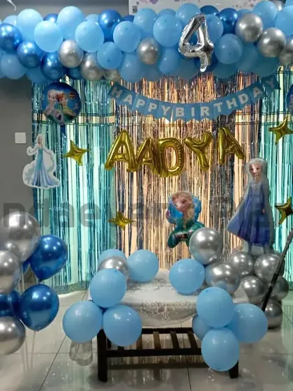 A cool "Frozen" themed birthday party for Aadya's 4th birthday. The decor features shades of blue and silver, with cutouts of Elsa and Olaf, creating a winter wonderland.