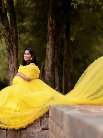 Brighten up your maternity shoot with this cheerful yellow off-shoulder netted tail gown. The long, flowing tail adds a touch of drama and playfulness to your photos, perfect for an outdoor setting.