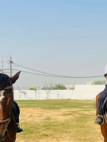 A front-facing view of two young riders sitting confidently on their horses, showcasing the progress they've made.