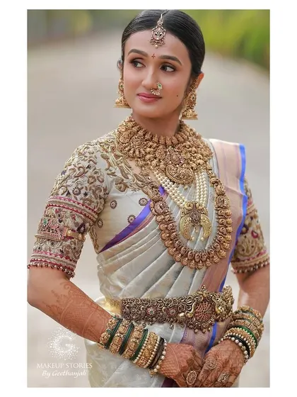 A detailed portrait of Vishnu Priya. This shot showcases the intricate antique jewelry and the heavily embroidered blouse, which we balanced with a classic, clean makeup look.
