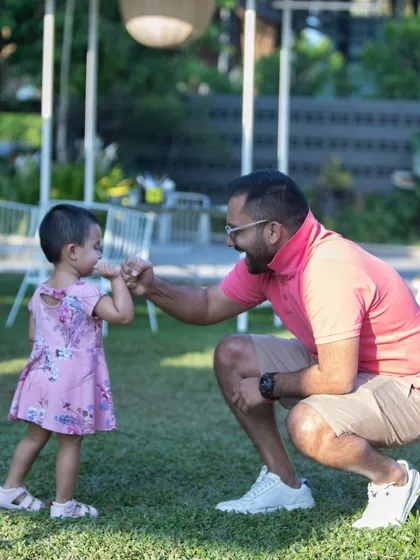 A heartwarming moment between a father and his daughter, sharing a fist bump on our lawn.