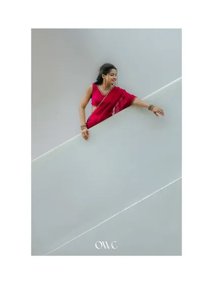 An artistic shot of the bride-to-be against a white architectural background, using negative space to create a striking image.