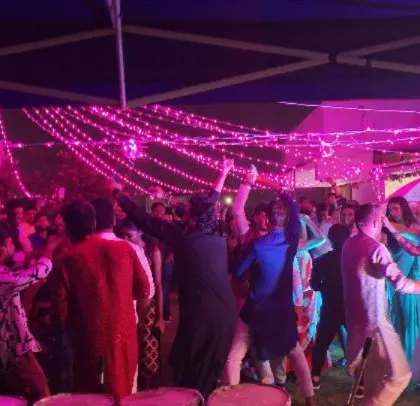 A corporate Diwali party with festive pink lighting and string lights, creating a celebratory mood.