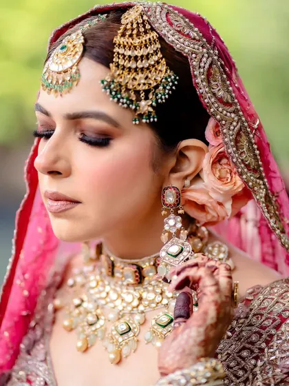 A beautiful shot of the bride's jewelry, with her mehendi in the background.