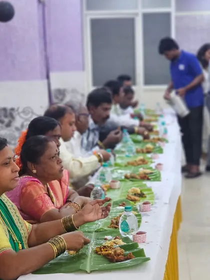A close-up of guests enjoying their meal, with a variety of colorful dishes visible on their banana leaves.