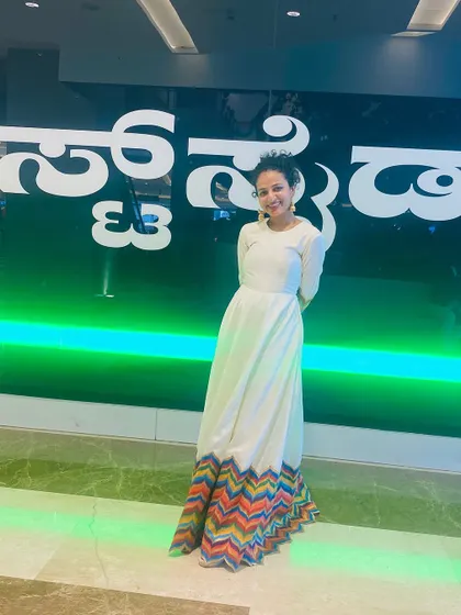 A stylish pose from Nisarga, showing the colorful details on the sleeves of the gown.