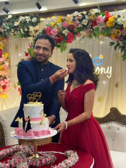 A sweet moment of celebration. The bride looks lovely in her red off-shoulder gown as they share cake at their ring ceremony.