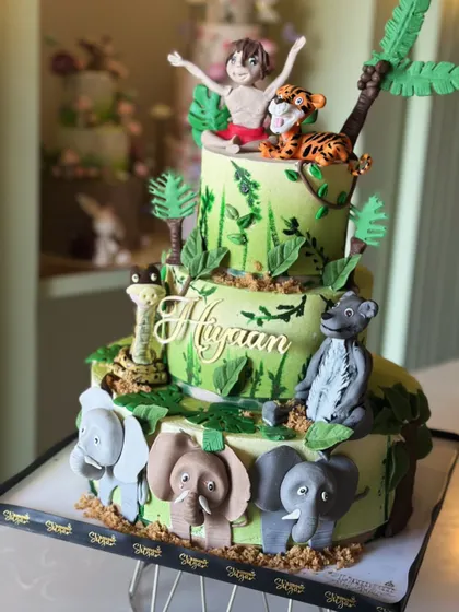 Welcome to the wild side! This jungle-themed cake is roaring with flavor, featuring adorable, handcrafted fondant animals like elephants, monkeys, and lions, perfect for a little explorer's party.