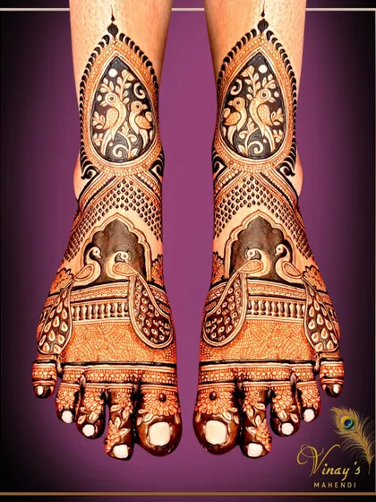 A bold and beautiful feet design with birds framed in paisley shapes. The dark henna application creates a stunning contrast, making the motifs stand out.