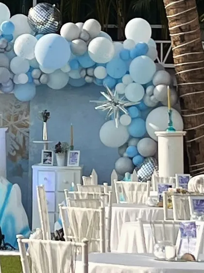 Another angle of the Frozen party setup, highlighting the beautiful balloon arch and the themed table settings.
