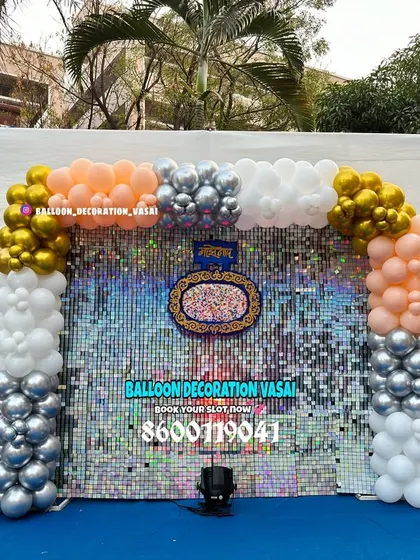 This naming ceremony backdrop makes a statement with a shimmering sequin wall. The balloon arch in peach, white, and chrome gold adds a touch of glamour to this outdoor setup.